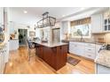 Open kitchen design with a large island, breakfast bar, stainless steel appliances, and custom cabinetry at 6964 S Olive Way, Centennial, CO 80112
