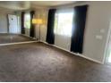 Open-concept living room with a mirrored wall and view of the outdoors at 598 Toledo St, Aurora, CO 80011