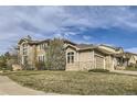 Expansive home shows manicured lawn, neutral paint, stone accents, and three car garage at 1007 Thorncreek Ct, Thornton, CO 80241