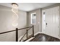 Chic foyer with stylish chandelier, sleek railing, and natural light, creating a grand and inviting entrance at 6766 Mentha Dr, Castle Rock, CO 80108