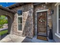 Inviting front entrance with stone accents, a wooden door with a wreath, and stylish decor at 15235 W Iliff Ave, Lakewood, CO 80228