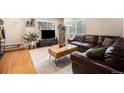 Cozy living room with hardwood floors, a comfortable leather sofa, and a modern media center at 895 Vance St, Lakewood, CO 80214