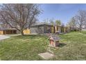 Spacious yard featuring mature trees, landscaping, and a detached garage, perfect for outdoor enjoyment at 6105 Lamar St, Arvada, CO 80003