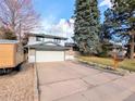 Exterior of home featuring a wide driveway and an attached garage, enhancing curb appeal at 3326 S Geneva St, Denver, CO 80231