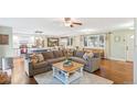 Open-concept living room boasts hardwood floors, a cozy sectional, and an adjoining kitchen and dining area at 3326 S Geneva St, Denver, CO 80231