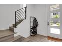 Bright entryway with wood floors, stairs, coat rack, and modern decor at 20999 E Quincy Dr, Aurora, CO 80015