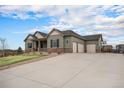 A well-landscaped home with a three-car garage and a large driveway, perfect for a Gathering at 23440 E Rockinghorse Pkwy, Aurora, CO 80016