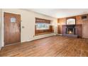 Inviting living room with a brick fireplace, hardwood floors, a large window, and natural light at 6185 Sheridan Blvd, Arvada, CO 80003