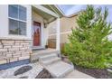 Charming entryway of home features a stone facade and covered porch at 6883 E 132Nd Pl, Thornton, CO 80602