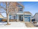 Two-story light blue house with stone accents and a snowy front yard at 6143 Gorham St, Frederick, CO 80530