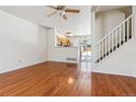 Living room with hardwood floors, a ceiling fan, and stairs at 6143 Gorham St, Frederick, CO 80530