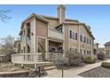 Two-story townhome with multiple balconies, a well-maintained lawn, and welcoming entryway at 8334 Pebble Creek Way # 201, Highlands Ranch, CO 80126