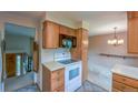 Bright kitchen with warm wood cabinets, a white range, and tiled floors, open to dining area at 790 Mohawk Dr, Boulder, CO 80303