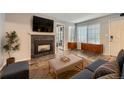 Living room showcasing a fireplace with a stone surround and built-in cabinets under bright windows at 836 S Vance St # D, Lakewood, CO 80226