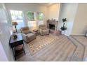 Comfortable living room featuring a brick fireplace, plush chairs, and natural light at 4760 S Wadsworth Blvd # F105, Littleton, CO 80123