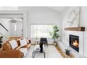 Bright living room featuring hardwood floors, large windows, and a modern fireplace at 6123 Dunraven Rd, Golden, CO 80403