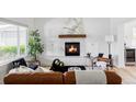 Cozy living room featuring hardwood floors, a stone fireplace, and stylish furnishings at 6123 Dunraven Rd, Golden, CO 80403