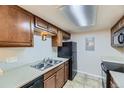 Functional kitchen features wood cabinets, black appliances, and a stainless steel sink at 18043 E Ohio Ave # 202, Aurora, CO 80017