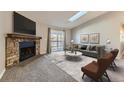 Bright living room with a stone fireplace, large windows, and a sliding door to the patio at 18043 E Ohio Ave # 202, Aurora, CO 80017