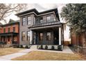 Modern two-story brick home featuring a covered porch, second-story balcony, and manicured lawn at 2751 Curtis St, Denver, CO 80205