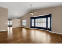 Bright living room featuring hardwood floors, a ceiling fan, and a large bay window at 8951 Greenwich St, Highlands Ranch, CO 80130