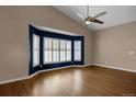 Spacious living room boasting hardwood floors, vaulted ceilings, and a bay window with white shutters at 8951 Greenwich St, Highlands Ranch, CO 80130