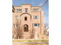 Detailed shot of the brick facade and arched entryway showcase the architectural charm of this townhouse at 2397 E Iliff Ave, Denver, CO 80210