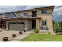 Two-story home featuring an attached two-car garage, front porch and a well maintained lawn at 10906 Touchstone Loop, Parker, CO 80134