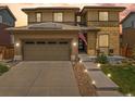 Attractive two-story home with a two-car garage, solar panels, and walkway lighting at 10906 Touchstone Loop, Parker, CO 80134