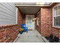 Charming front porch with brick accents and a cozy blue chair with flowers at 9491 Southern Hills Cir, Lone Tree, CO 80124