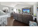 Open concept living room featuring hardwood floors, vaulted ceiling, and modern gray furniture set at 21111 E 43Rd Ave, Denver, CO 80249