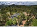 An aerial shot reveals a well-maintained estate with mature trees and fencing in a picturesque wooded setting at 97 Soda Creek Rd, Evergreen, CO 80439