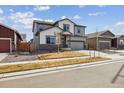 Charming two-story home featuring gray and white siding, a well-kept lawn, and an attached two-car garage at 8852 Ventura St, Commerce City, CO 80022