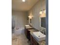 Spacious bathroom with dual vanities, granite countertops, vessel sinks, a soaking tub, and a glass-enclosed shower at 20678 E Lake Cir, Centennial, CO 80016