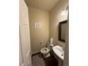Cozy powder room featuring a pedestal sink, toilet, decorative sign, and modern fixtures at 20678 E Lake Cir, Centennial, CO 80016