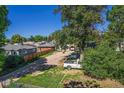 Backyard with mature tree, parking area, and fenced neighboring home at 449 Lowell Blvd, Denver, CO 80204