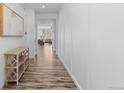 Inviting hallway with hardwood floors, a console table, and access to the living areas at 17960 Weymouth Ave, Parker, CO 80134