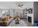 Bright living area featuring a cozy fireplace, comfortable sofas, and plenty of natural light at 17960 Weymouth Ave, Parker, CO 80134