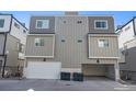 Rear exterior view of the townhome with a two-car garage and ample parking space at 8500 W 62Nd Ave # D, Arvada, CO 80004