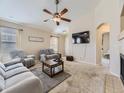 Spacious living room with plush carpeting, a ceiling fan, and abundant natural light at 24704 E Chenango Dr, Aurora, CO 80016