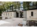 Modern building exterior with a clean design, featuring trees, plants, and concrete pavers at 1050 N Corona St # 312, Denver, CO 80218