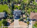 Aerial view of a two-story home with landscaped yard, mature trees, a driveway, and surrounding neighborhood at 6258 Lancaster Ave, Castle Rock, CO 80104