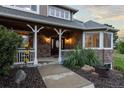 Charming front porch with brick accents and decorative plants welcomes visitors at 5604 Singletree Ln, Parker, CO 80134