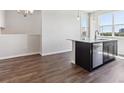 Kitchen island with dark cabinets, white countertop, stainless steel dishwasher and wood flooring at 457 Interlocken Blvd # 101, Broomfield, CO 80021