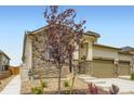 Exterior of home showcasing well-manicured landscaping, stone facade, and tan siding at 3461 N Buchanan Way, Aurora, CO 80019