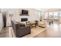 Open concept living room with hardwood floors, fireplace, and ample natural light at 3461 N Buchanan Way, Aurora, CO 80019
