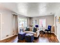Bright living room featuring hardwood floors, neutral walls, and stylish, comfortable furnishings at 745 S Utica St, Denver, CO 80219