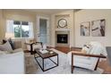 Cozy living room with a fireplace, armchairs, and a neutral-toned color palette at 8255 E 150Th Pl, Thornton, CO 80602