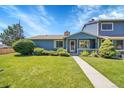 Charming blue home with a well-maintained lawn and landscaping on a sunny day at 10116 Quivas St, Thornton, CO 80260