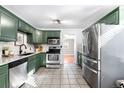 Bright kitchen features stainless steel appliances, green cabinets, and light countertops at 2610 Poplar St, Denver, CO 80207